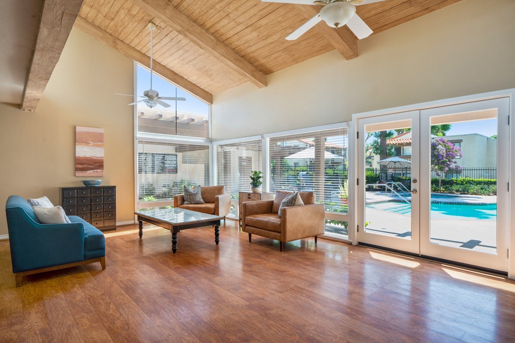 a living room with a view of a pool and sliding glass doors