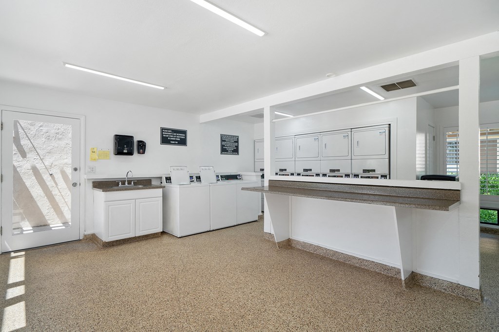 a kitchen with white cabinets and counters and a counter top