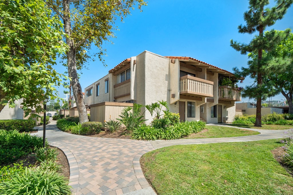 a building with a walkway and trees in front of it