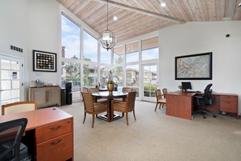 an office with a table and chairs and large windows