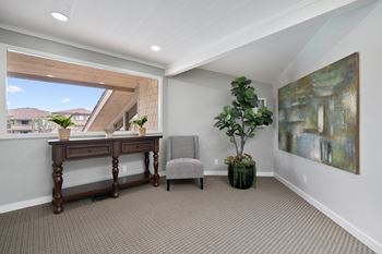 the upstairs office has a large window and a desk with a chair