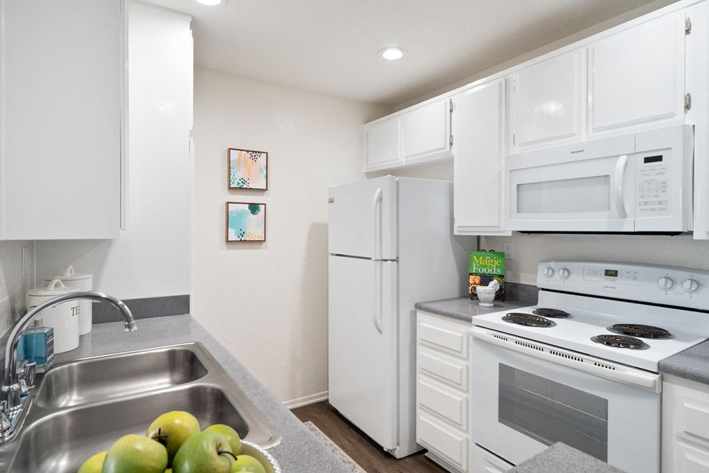 a kitchen with white appliances and a sink