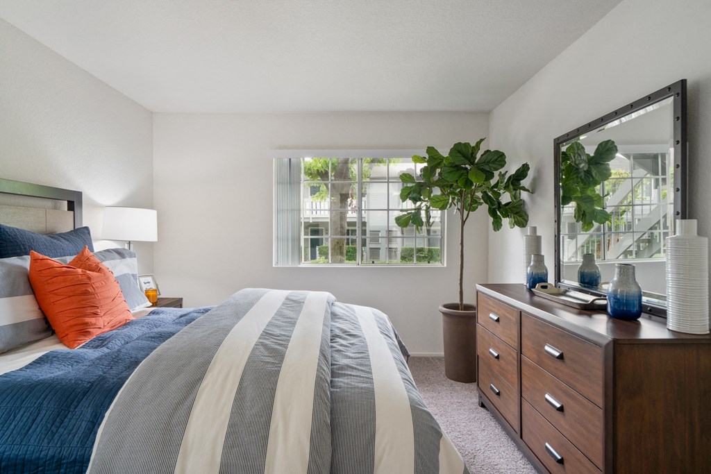 a bedroom with a bed and a dresser and a window