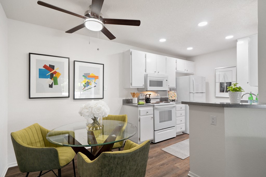 an open kitchen and dining area with a glass table and chairs
