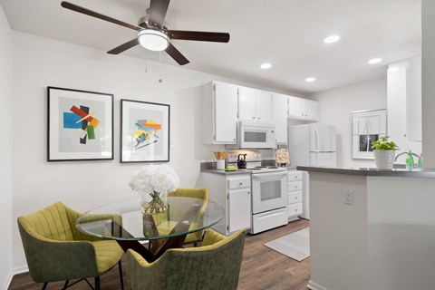 an open kitchen and dining area with a glass table and chairs