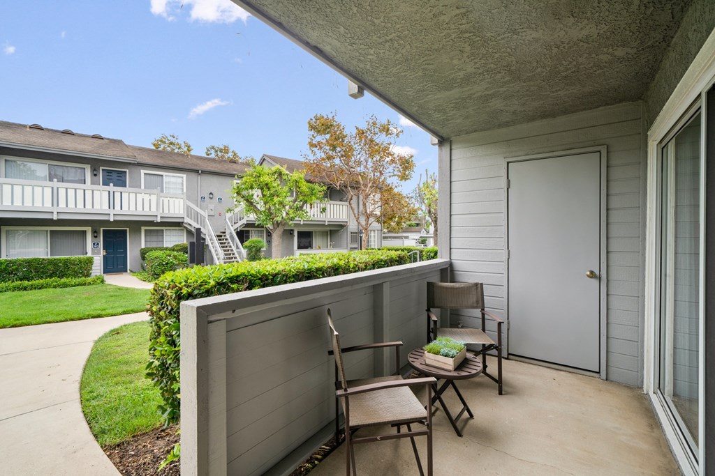 a patio with two chairs and a door to a building
