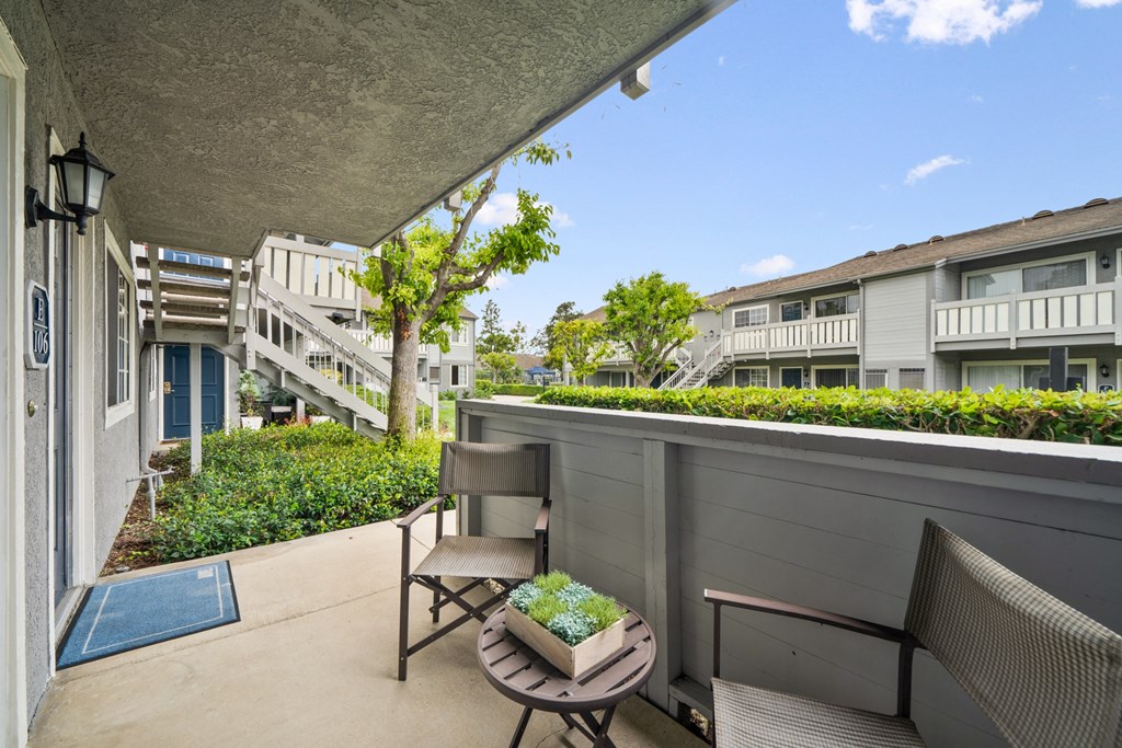 a balcony with two chairs and a table on a balcony