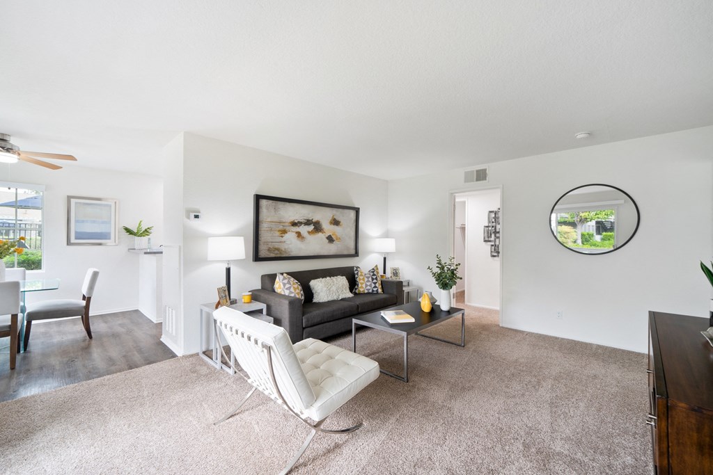 a living room with a couch and a chair and a dining room table