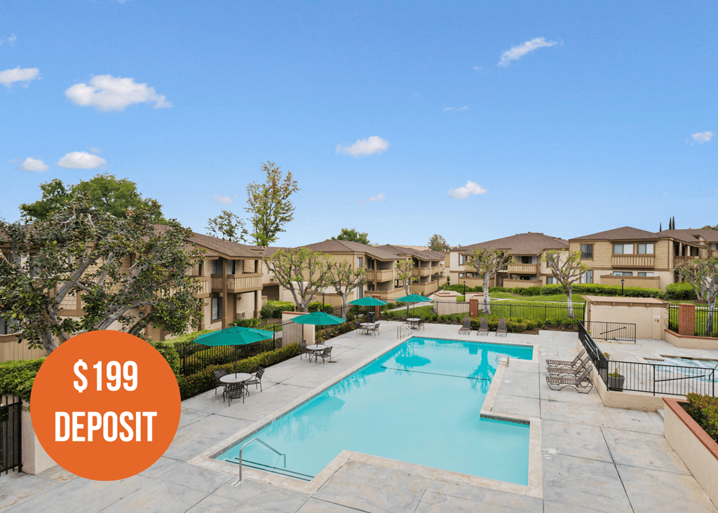 a swimming pool with umbrellas and buildings in the background