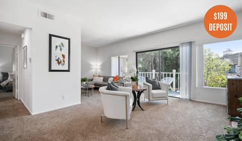A living room with a white sofa and a painting on the wall.