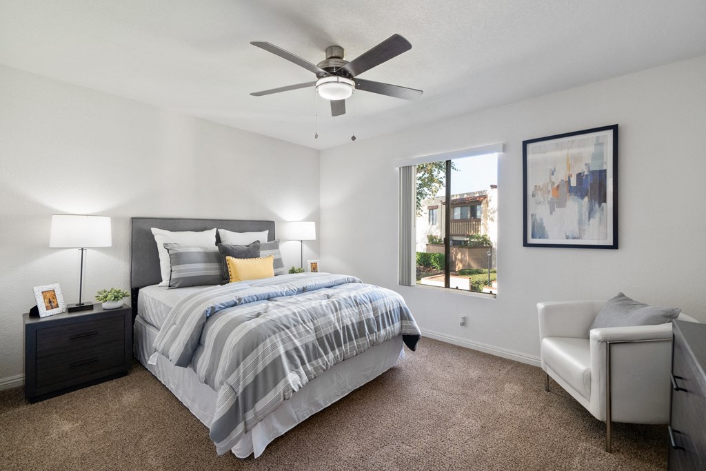 a bedroom with a bed and a ceiling fan