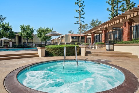 a hot tub with a fountain in the middle of a resort style pool