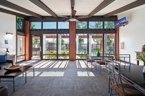 a living room with tables and chairs and a large window