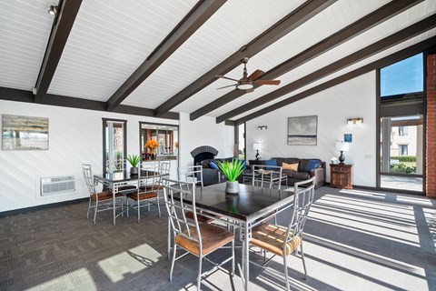 a living room with a table and chairs and a ceiling fan