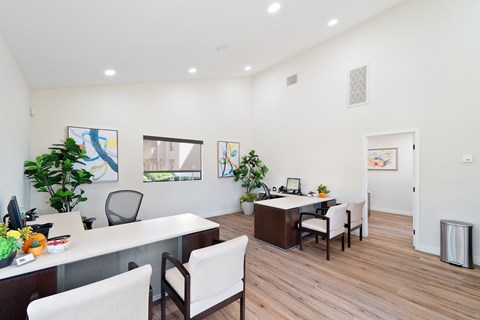 an office space with two desks and chairs and a table with a computer