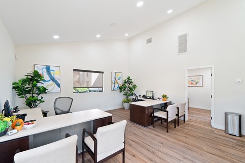 an office space with two desks and chairs and a table with a computer
