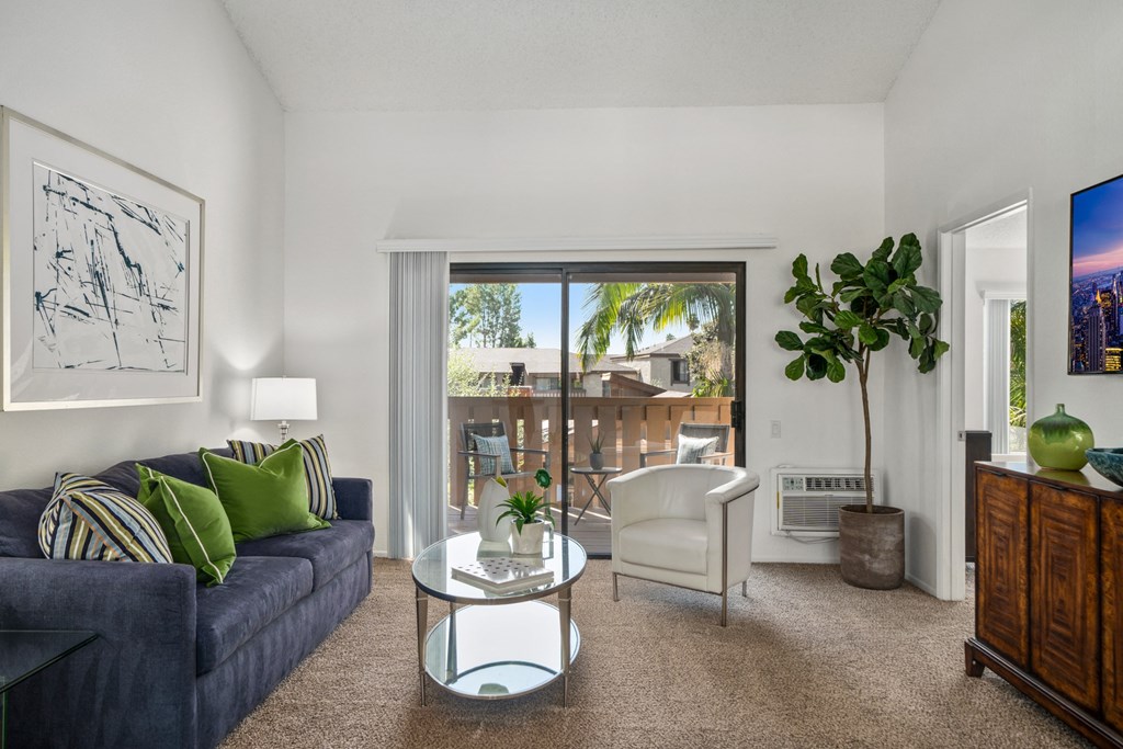 a living room with a blue couch and a glass coffee table