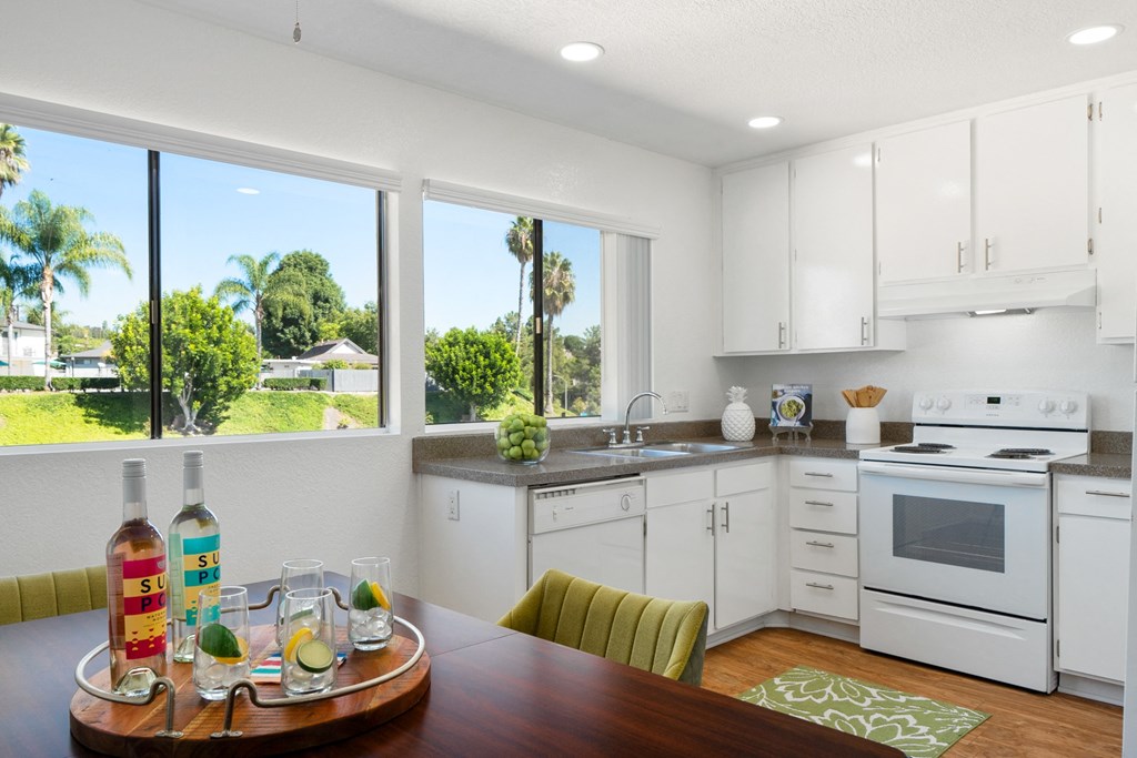 a kitchen with white cabinets and a wooden table