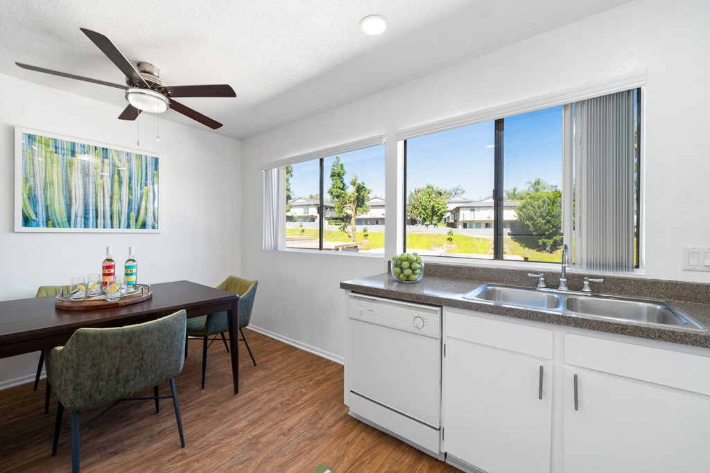 a kitchen and dining room with a large window and a ceiling fan