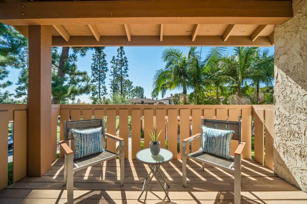 a patio with two chairs and a table on a balcony
