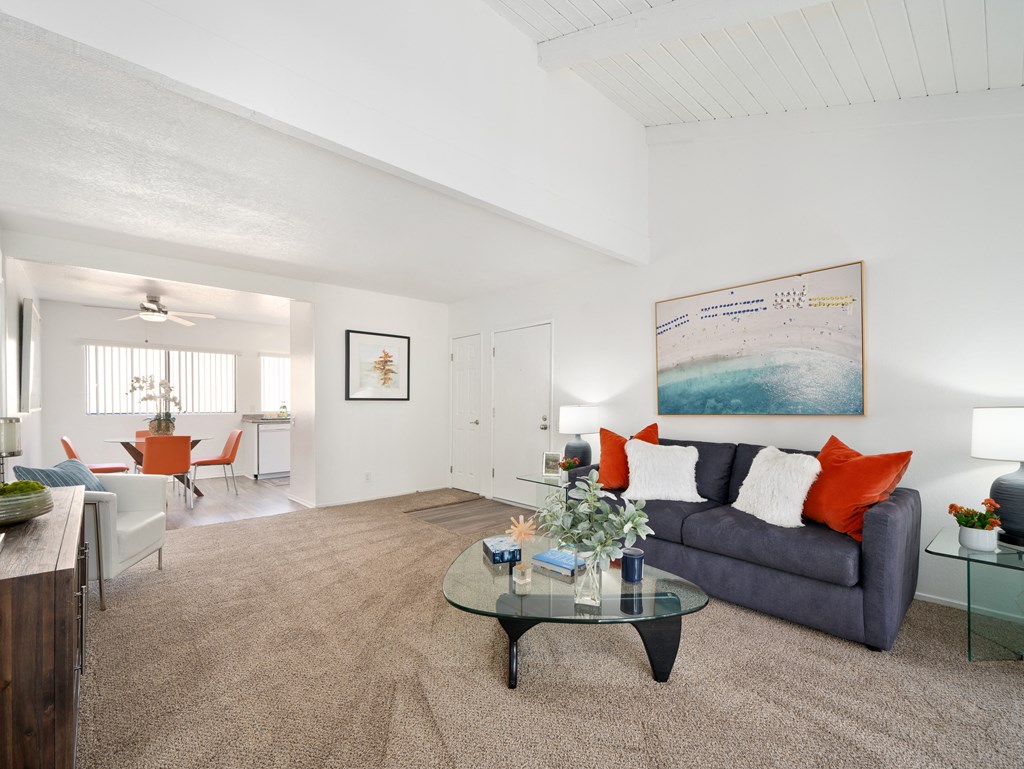 a living room with a blue couch and a glass coffee table