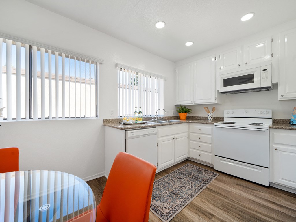 a kitchen with white cabinets and a white stove top oven