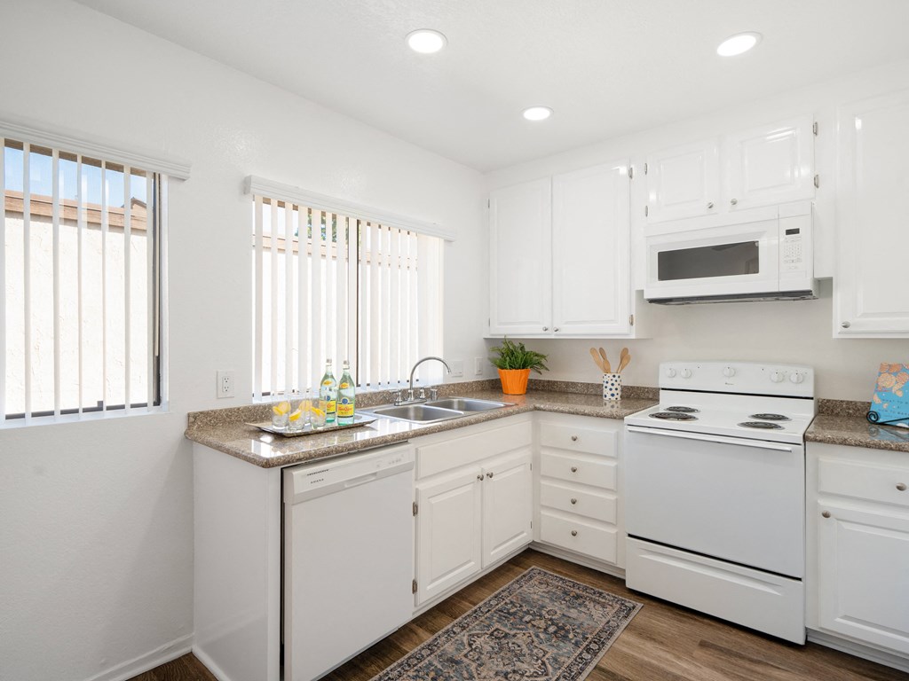a kitchen with white cabinets and white appliances