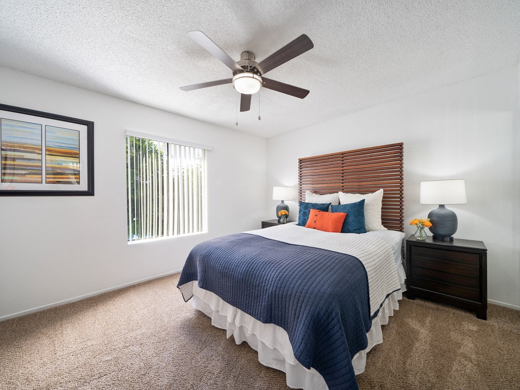 a bedroom with a large bed and a ceiling fan