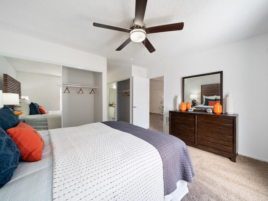 a bedroom with a large bed and a ceiling fan