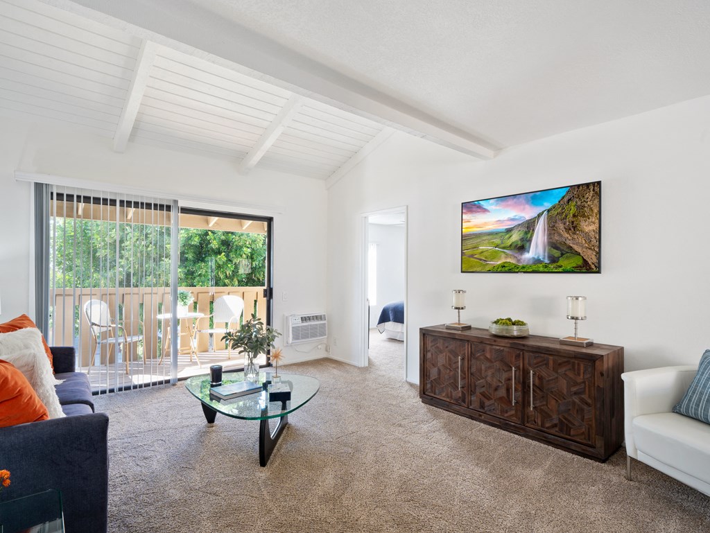 a living room with white walls and a glass coffee table