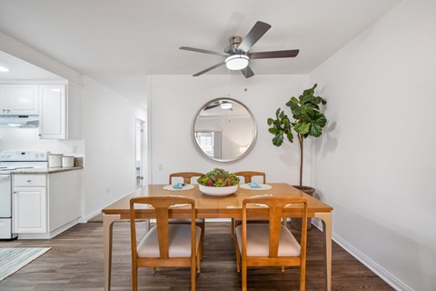 a dining room with a table and chairs and a ceiling fan