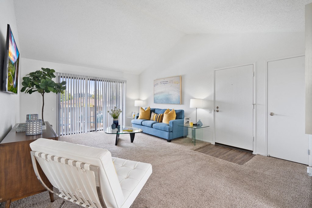 a living room with a blue couch and a white chair