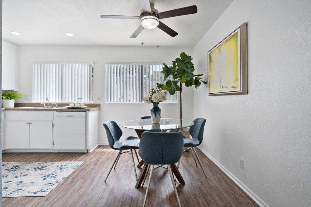 a dining room with a table and chairs and a ceiling fan
