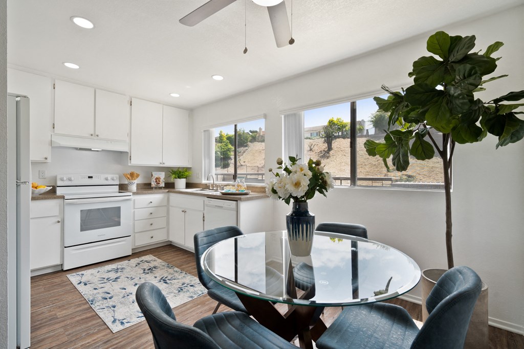 an open kitchen and dining area with a glass table and chairs