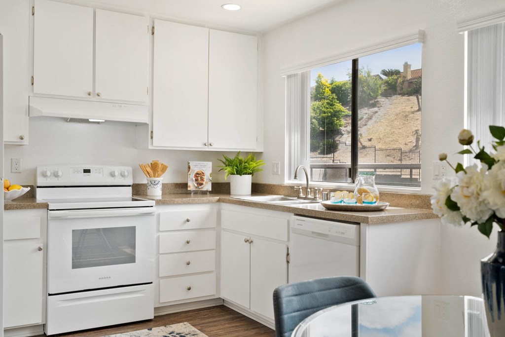 a white kitchen with white appliances and white cabinets
