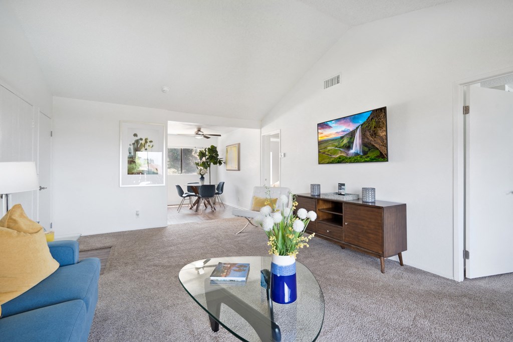a living room with a blue couch and a glass coffee table