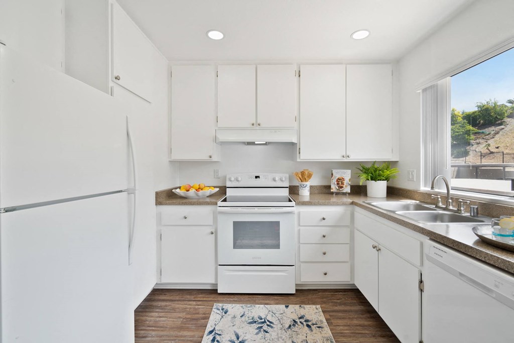 a white kitchen with white appliances and white cabinets