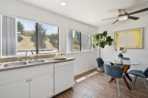A kitchen with white cabinets and a table with chairs.