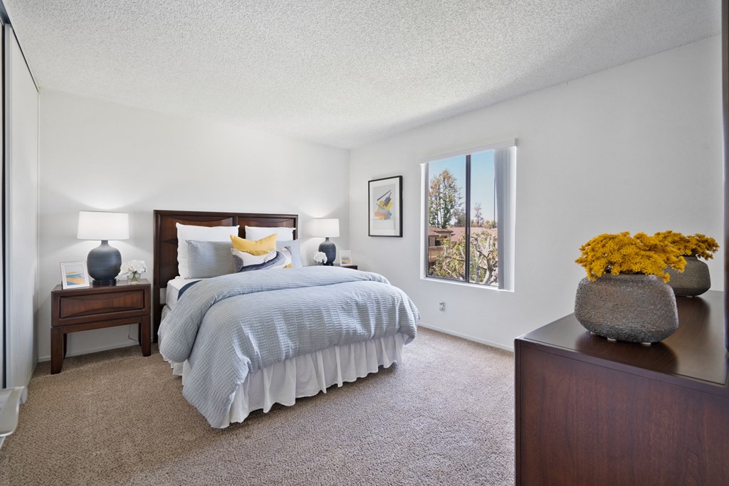 a bedroom with a bed and a dresser and a window