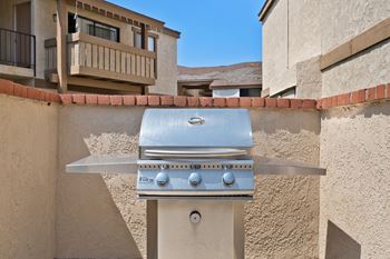 a stainless steel barbecue grill on the side of a building