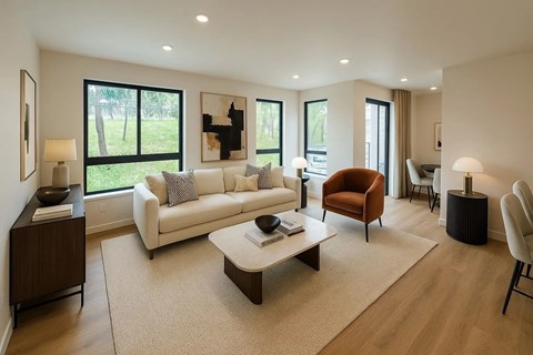 A living room with a white couch and a brown armchair.