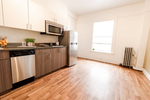 A kitchen with wooden floors and stainless steel appliances.
