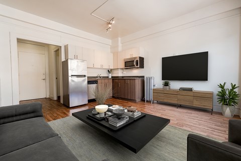 A modern living room with a grey couch and a black coffee table.