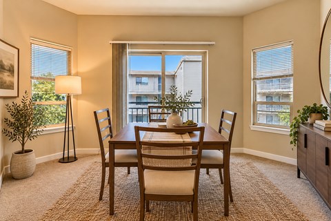 A dining room with a table set for four.