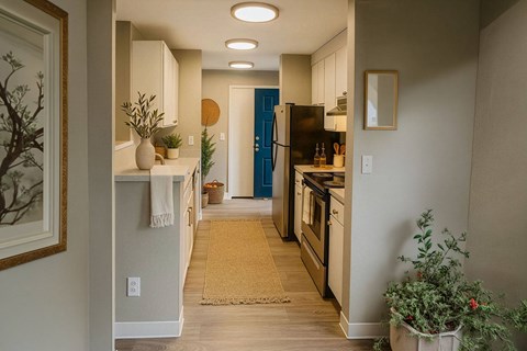 A kitchen with a blue refrigerator and wooden floors.
