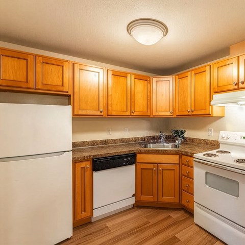 A kitchen with wooden cabinets and white appliances.