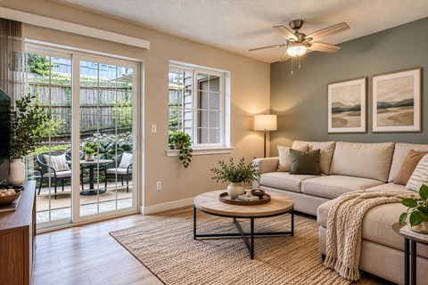 A living room with a couch, a coffee table, and a ceiling fan.