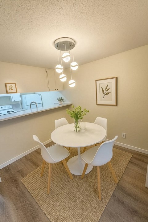 A dining room with a white table and chairs.