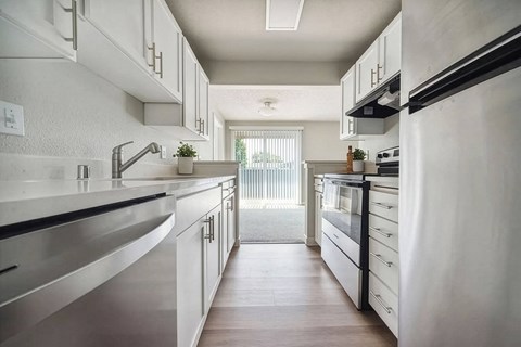 A modern kitchen with white cabinets and stainless steel appliances.