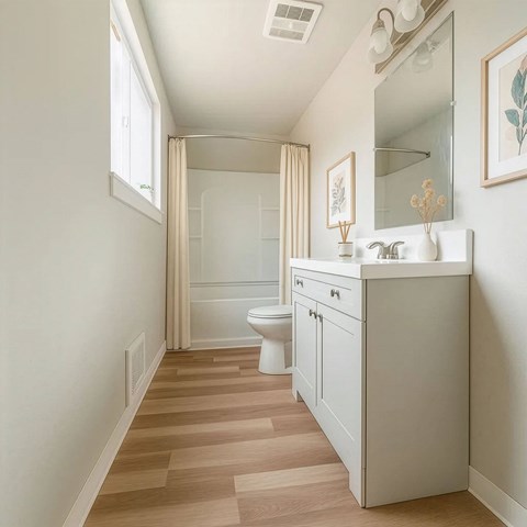 A bathroom with a white vanity and a walk-in shower.